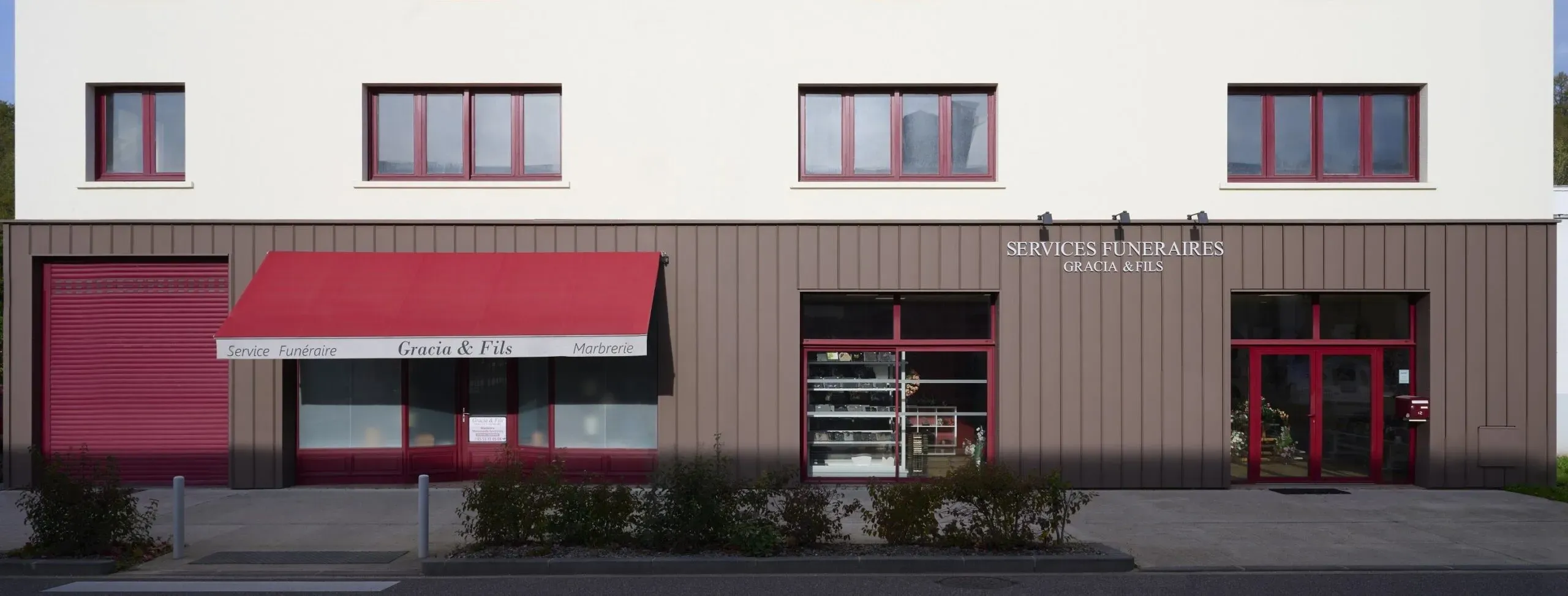 Façade moderne de l'agence Services Funéraires Gracia & Fils avec store bordeaux